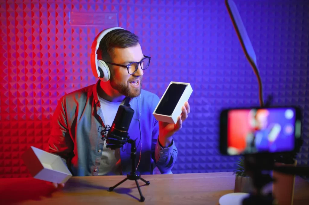 Produtor grava conteúdo enquanto recebe produto eletrônico patrocinado, uma forma de podcast ganhar dinheiro